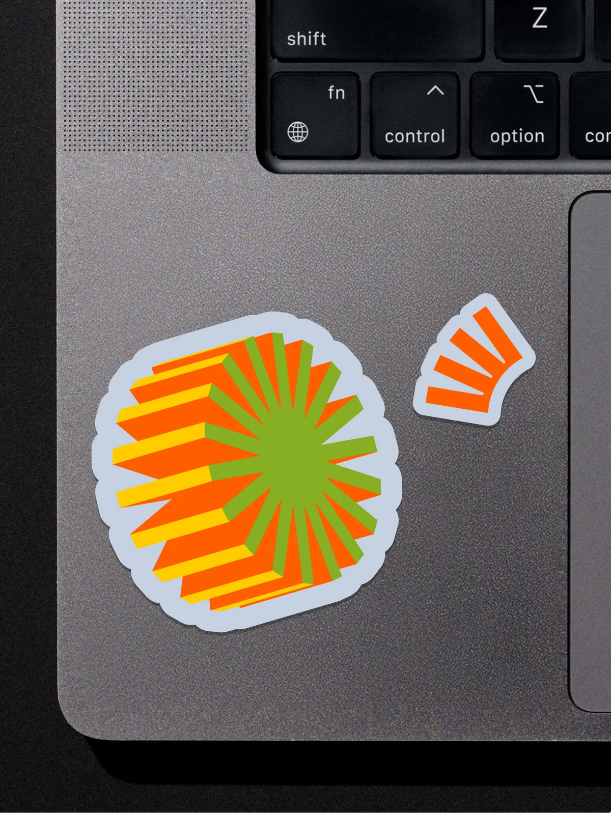 Stack Overflow brand-shape stickers on a laptop, beside the keyboard